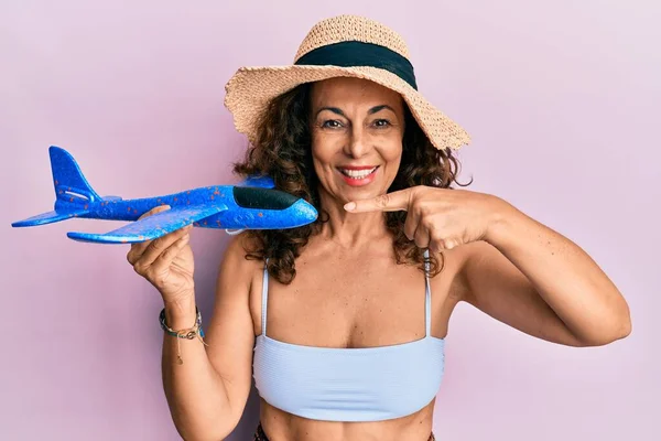 Middle Age Hispanic Woman Wearing Bikini Summer Hat Holding Plane — Stock Photo, Image