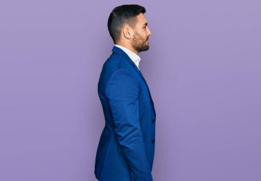 İş ceketi giyen genç İspanyol bir adam. Taraf arıyor, profil pozu veriyor. Doğal bir yüz ve kendine güvenen bir gülümseme.. 