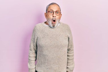 Sakallı, sıradan bir süveter ve gözlüklü yakışıklı bir adam. Şaşırmış ve şaşırmış bir ifade, korku ve heyecanlı bir yüz ifadesi var.. 