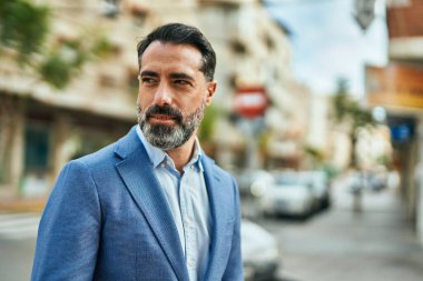 Şehirde duran rahat yüzlü orta yaşlı iş adamı..