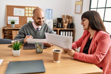 Ofiste çalışırken gülümseyen iki İspanyol iş adamı..