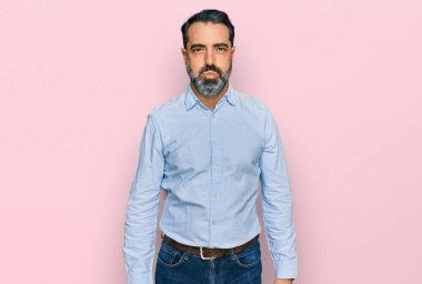 Sakallı, iş gömleği giyen, komik suratlı orta yaşlı bir adam. Havayla şişmiş ağız, çılgın bir ifade.. 