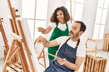 Sanat okulunda resim yaparken gülümseyen orta yaşlı öğrenci ve öğretmen..