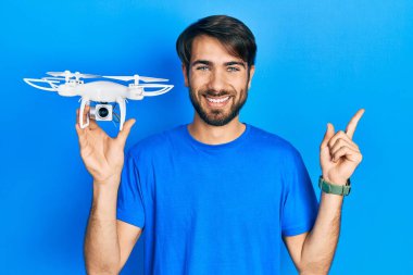 İHA 'yı tutan genç İspanyol adam gülümsüyor. 