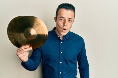 Elinde altın zilli levhalar tutan yakışıklı genç adam şaşıracak şekilde ağzı açık, korkmuş ve hayrete düşmüştü. 