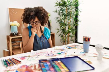 Sanat stüdyosunda afro saçlı güzel Afro-Amerikalı kadın kendini iyi hissetmiyor ve soğuk algınlığı veya bronşitin belirtisi olarak öksürüyor. sağlık hizmeti kavramı. 