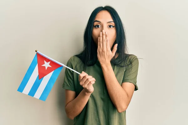 若いヒスパニック系の女の子の手で口をカバーし キューバのフラグを保持ショックを受け ミスを恐れている 驚きの表情 — ストック写真