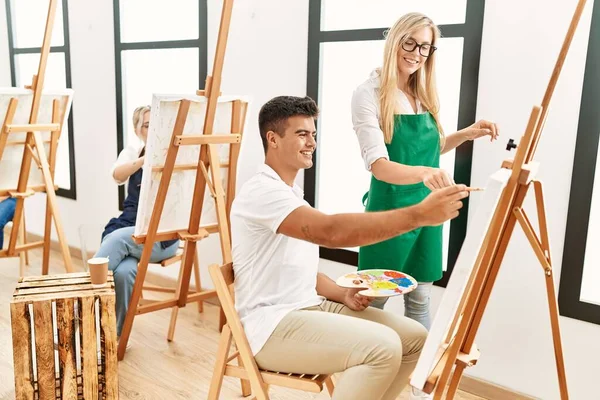 美術教師笑顔幸せそうな絵を描く学生でスタジオ — ストック写真