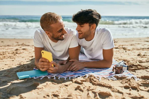 Νεαρό Ομοφυλόφιλο Ζευγάρι Που Χρησιμοποιεί Smartphone Ξαπλωμένο Στην Άμμο Στην — Φωτογραφία Αρχείου