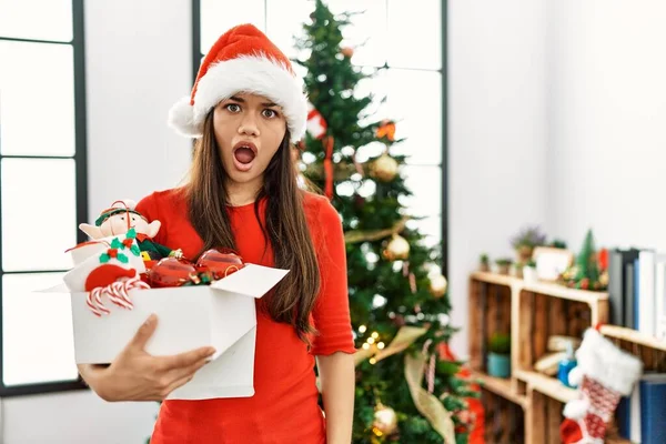 Jovem Morena Junto Árvore Natal Segurando Decoração Face Choque Parecendo — Fotografia de Stock