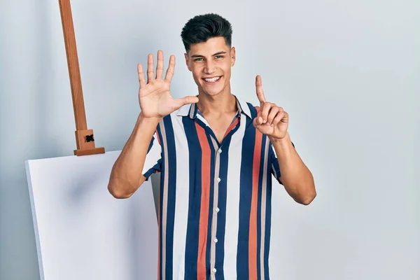 Genç Spanyol Adam Boş Tuvalin Yanında Duruyor Altıncı Parmaklarını Gösterip — Stok fotoğraf
