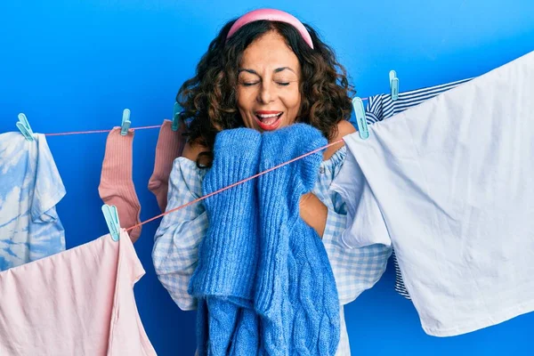 西班牙裔中年妇女正在洗衣服 身上散发着干净衣服的香味 — 图库照片
