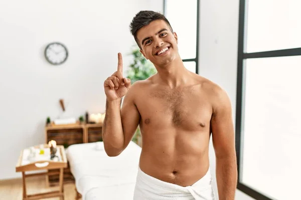 Ung Latinamerikansk Man Står Tröjlös Spa Center Visar Och Pekar — Stockfoto