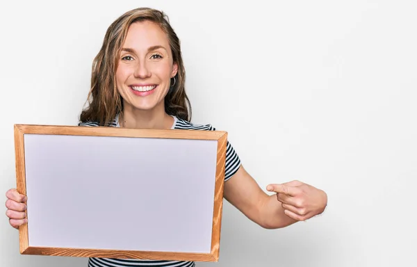 Jovem Loira Segurando Placa Branca Vazia Sorrindo Feliz Apontando Com — Fotografia de Stock