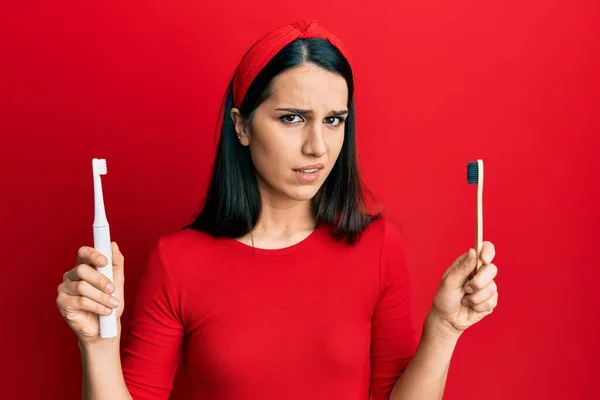 Mujer Hispana Joven Eligiendo Cepillo Dientes Eléctrico Cepillo Dientes Normal —  Fotos de Stock