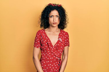 Yazlık elbise giyen genç Latin kız şüpheci ve gergin, sorun yüzünden surat asıyor. negatif kişi. 