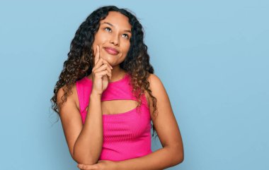 Pembe bluzlu, kıvırcık saçlı, genç İspanyol kadın. Ciddi bir yüz ifadesi var. Elleri çenesinde soru sormayı düşünüyor. 