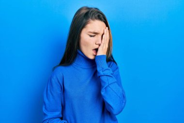 Balıkçı yaka kazak giyen genç esmer kız yarı yüzünü, göz ve ağzını eliyle kapatarak yorgun esniyor. Yüzüm acıyor.. 