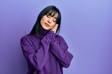 Kâküllü genç esmer kadın balıkçı yaka kazak giyiyor. Uyuyor, yorgun. Hayal kuruyor, elleriyle poz veriyor, gözleri kapalı gülümsüyor.. 