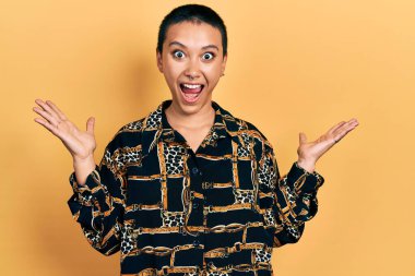 Kısa saçlı, zarif gömlekli güzel İspanyol kadın zaferi mutlu bir gülümsemeyle kutluyor ve ellerini kaldırarak kazanan yüz ifadesi takınıyor. 