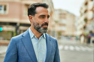 Orta yaşlı işadamı şehirde mutlu mesut dikilirken.