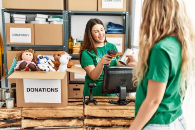 İki gönüllü kadın, hayır kurumunda çalışmaktan mutlu gülümsüyor..