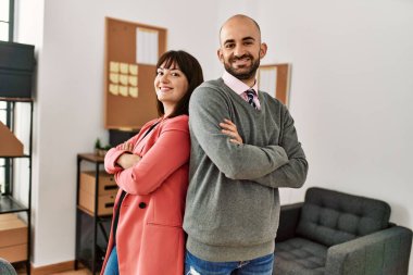 İki iş adamı kollarını kavuşturup mutlu bir şekilde gülümsüyor ve ofiste bekliyorlar..