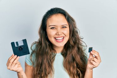 Disket ve SDxc kartı tutan genç İspanyol kız kahkahalarla gülüyor.. 