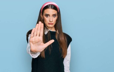 Gayri resmi beyaz gömlek giyen genç ve güzel bir kadın avucunun içi gibi şarkı söylemeyi kesiyor. Yüzünde olumsuz ve ciddi bir jest olan uyarı ifadesi. 