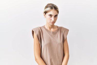 Soyutlanmış arka planda duran genç sarışın kadın yüzünde ciddi bir ifadeyle rahatlamış. Basit ve doğal bir şekilde kameraya bakıyorsun.. 