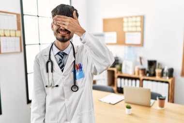 Sakallı, doktor üniforması giyen, steteskop takan, gülümseyen ve gülen İspanyol bir adam. kör kavram. 