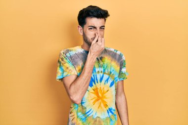 Gündelik kıyafetler giyen genç İspanyol adam pis ve iğrenç bir koku alıyor, dayanılmaz bir koku, nefesini burnunda tutuyor. Kötü kokuyor. 