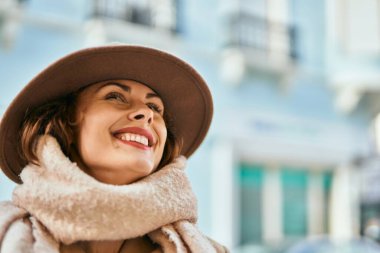 Şık giyinen genç İspanyol kadın şehirde dikiliyor..