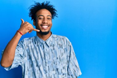 Sakallı, sıradan kıyafetler giyen, telefonla el ve parmak hareketi yapan telefonda konuşan Afro-Amerikalı genç bir adam. iletişim kavramları. 