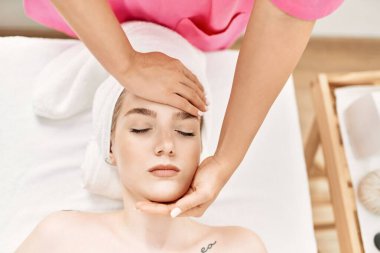 Beyaz kadın güzellik merkezinde yüz masajı yaptırıyor..