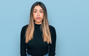 Günlük kıyafetler giyen genç İspanyol kadın komik yüzlü yanakları şişiriyor. Havayla şişmiş ağız, çılgın bir ifade.. 