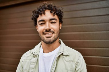 Yakışıklı, sakallı, güneşli bir günde mutlu bir şekilde gülümseyen bir İspanyol.