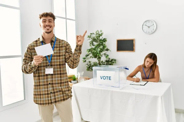 Jovem Homem Bonito Votando Colocando Envoltório Urna Sorrindo Feliz Apontando — Fotografia de Stock