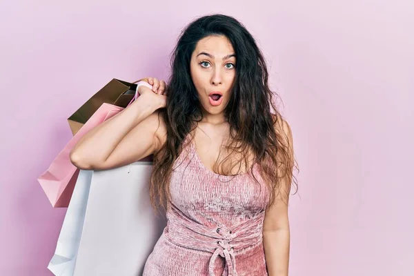 Young Hispanic Woman Holding Shopping Bags Scared Amazed Open Mouth — Stock Photo, Image