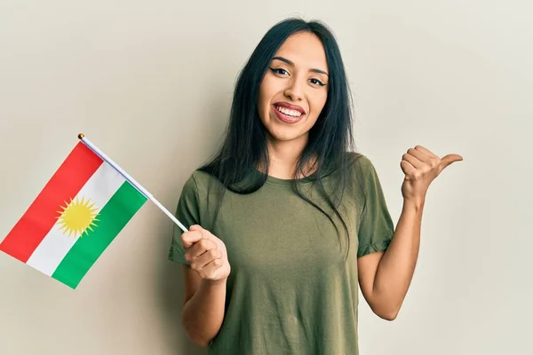 Menina Hispânica Jovem Segurando Bandeira Curdistão Apontando Polegar Até Lado — Fotografia de Stock