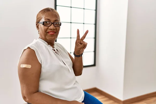 Mujer Hispana Madura Recibiendo Vacuna Mostrando Brazo Con Tirita Sonriendo —  Fotos de Stock