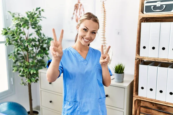 Mulher Caucasiana Jovem Trabalhando Clínica Recuperação Dor Sorrindo Olhando Para — Fotografia de Stock