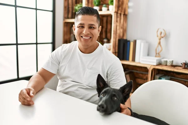 Jovem Hispânico Sorrindo Feliz Sentado Mesa Com Cão Casa — Fotografia de Stock