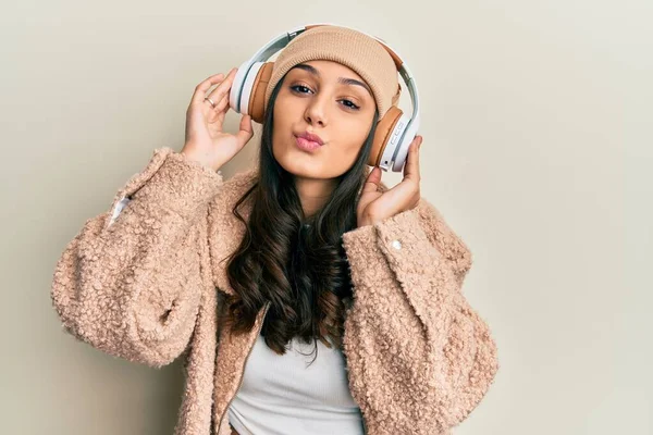 Mujer Hispana Joven Escuchando Música Usando Auriculares Mirando Cámara Soplando — Foto de Stock