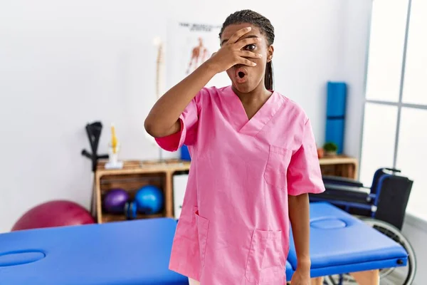 Молодая Африканская Американка Работающая Клинике Восстановлению Боли Подглядывает Рукой Лицо — стоковое фото