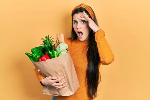 Young Brunette Teenager Holding Paper Bag Groceries Smiling Hands Chest — Stock Photo, Image