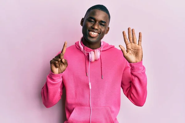 Νεαρός Αφροαμερικάνος Που Φοράει Ρούχα Γυμναστικής Και Χρησιμοποιεί Ακουστικά Δείχνοντας — Φωτογραφία Αρχείου