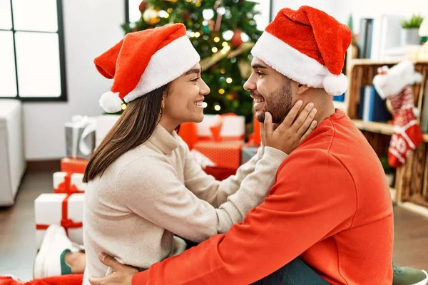 Jovem Casal Hispânico Sorrindo Feliz Abraçando Sentado Árvore Natal Casa — Fotografia de Stock