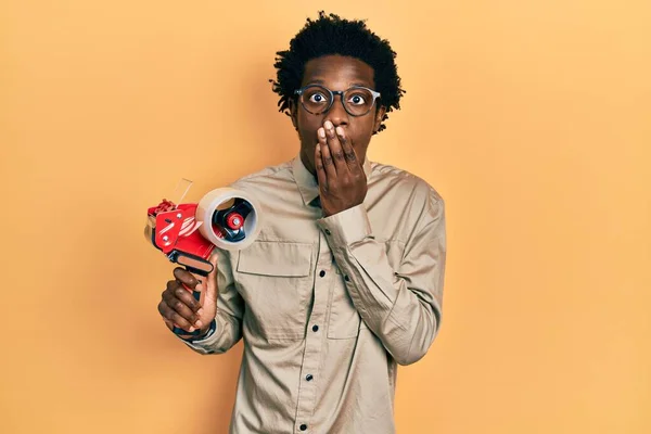 Joven Hombre Afroamericano Sosteniendo Máquina Embalaje Cinta Que Cubre Boca — Foto de Stock