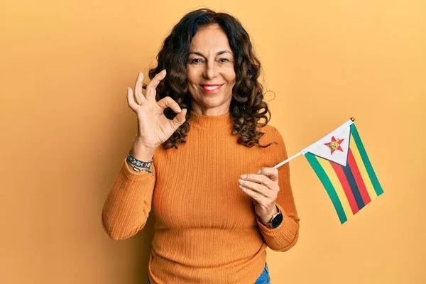 Middelbare Leeftijd Spaanse Vrouw Met Zimbabwe Vlag Doet Teken Met — Stockfoto